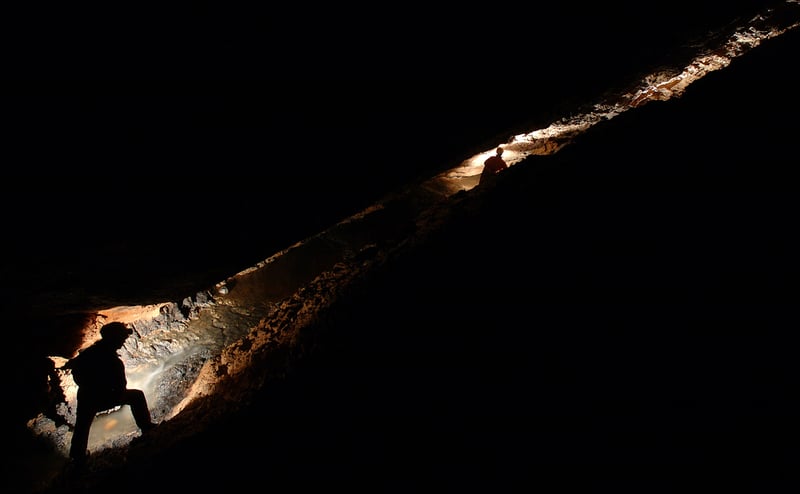 A spelunker makes the descent into the cave