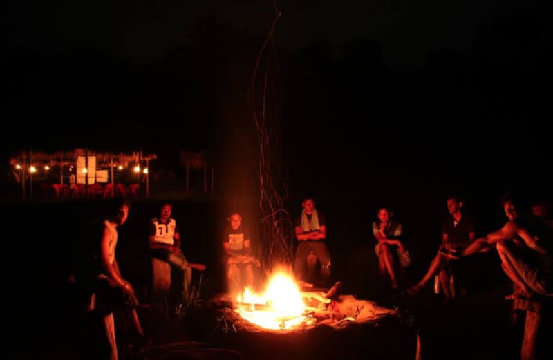 Campers by a bonfire in Coorg